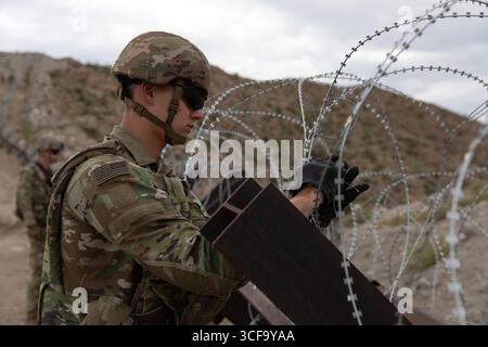 Sunland Park, Usa. August 2025. Alexander Letroadec, zusammen mit der 642nd Engineer Support Company, der Joint Task Force-Southern Border zugewiesen wurde, installiert am 16. August 2025 in der Nähe des Sunland Park, New Mexico, ein Concertina-Draht entlang der südlichen Grenzmauer zu Mexiko. Quelle: Michael Graf/US Army Photo/Alamy Live News Stockfoto