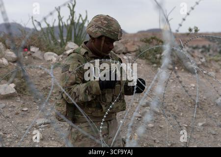 Sunland Park, Usa. August 2025. Dominick Harrison, 1. Klasse der US-Armee, mit der 642nd Engineer Support Company, die der Joint Task Force-Southern Border zugewiesen ist, installiert am 16. August 2025 in der Nähe des Sunland Park, New Mexico, eine Drahtverbindung entlang der südlichen Grenzmauer zu Mexiko. Quelle: Michael Graf/US Army Photo/Alamy Live News Stockfoto