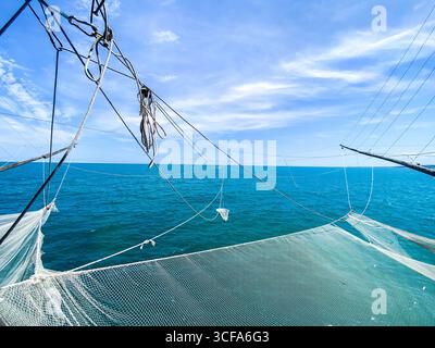 Fischernetze, die an einem Trabucco, einer traditionellen Fischereiplattform, an einem blauen Meer und Himmel an der Adriaküste in Rocca San Giovanni, den Abruzzen hängen, Stockfoto