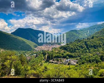 Panoramablick auf Scanno, ein bezauberndes Dorf in den Abruzzen, Italien, umgeben von üppigen grünen Bergen und einem dramatischen bewölkten Himmel Stockfoto