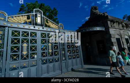 An einem sonnigen Nachmittag gehen die Menschen aus dem historischen Löwentor im Zoo Berlin, dem ehemaligen Haupteingang des Zoologischen Gartens. Stockfoto