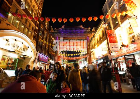 LONDON, GROSSBRITANNIEN. FEBRUAR 2015. Die Menschenmassen versammeln sich unter roten Laternen und dem geschmückten Tor von Chinatown, um das chinesische Neujahrsfest in der Nacht zu feiern Stockfoto