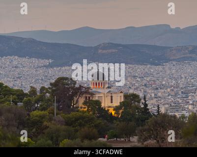 Blick auf Athen mit der Kuppel des National Observatory, umgeben von urbaner Zersiedelung und fernen Bergen Stockfoto