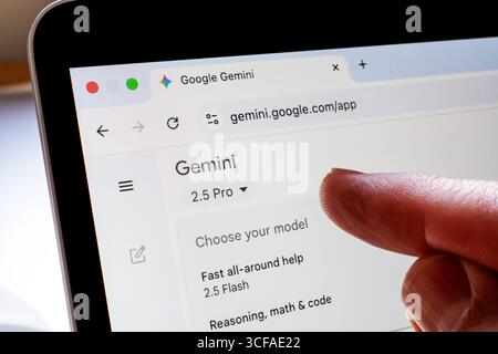 Tippen Sie mit der Hand auf die Google Gemini-Schnittstelle auf dem Laptop, und wählen Sie im Modellmenü im Browser „2,5 Pro“ aus. Stafford, Vereinigtes Königreich, 21. August 2025 Stockfoto