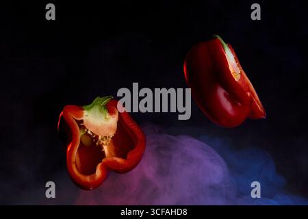 Gruppe roter Paprika auf einer schwarzen strukturierten Oberfläche Stockfoto