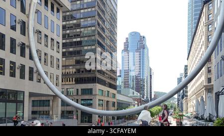 Montreal QC, Kanada - 20. Juli 2025: Die Ring-Skulptur befindet sich am Place Ville Marie in Montreal, eingerahmt von zeitgenössischer Architektur und lebhaftem Stree Stockfoto