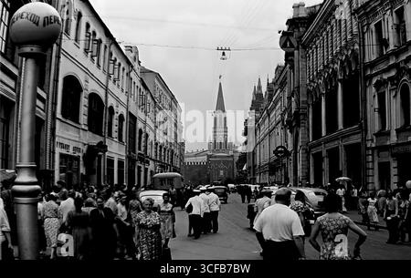 Menschen und Autos auf der 25. Oktoberstraße (heute Nikolskaja) mit dem Nikolskaja-Turm des Kreml im Hintergrund, Moskau, UdSSR, 1959 – eine Szene des täglichen Lebens in der sowjetischen Hauptstadt Stockfoto
