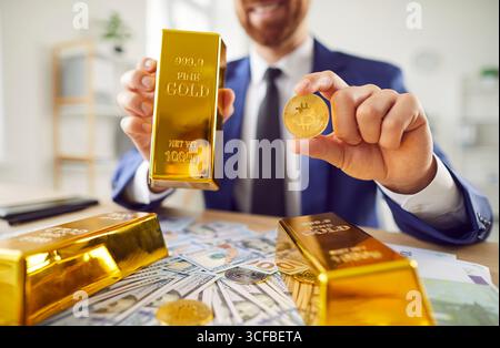 Nahaufnahme Eines Geschäftsmannes, der Gold Bar und Bitcoin Coin hält Stockfoto