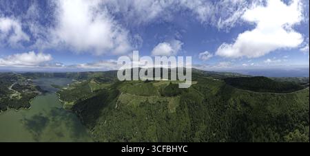 Aus der Vogelperspektive auf zwei Kraterseen, eingebettet in grüne Hügel unter einem Wolkenhimmel, Sete Cidades, Azoren, Portugal. Stockfoto
