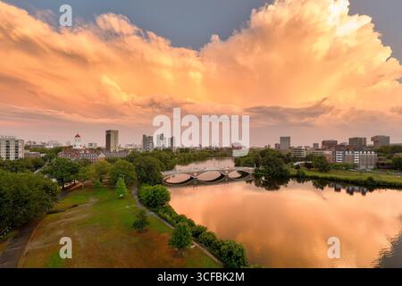 Aus der Vogelperspektive auf den Charles River, der den feurigen Sonnenuntergang reflektiert, mit den Gebäuden der Harvard University in Cambridge, Massachusetts, USA. Stockfoto