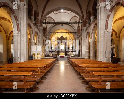 Innenansicht des Hauptschiffs und der Holzbankreihen in der alten Basilika Sant'Ambrogio in Mailand, Italien Stockfoto