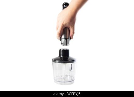 Moderner Eintauchmixer mit einer Schüssel in der Hand auf weißem Hintergrund, isolieren. Stockfoto