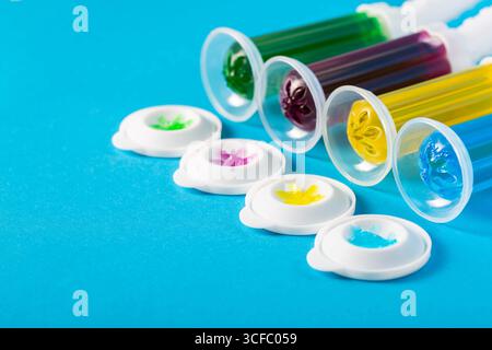 Set aus mehrfarbigen Gelspritzen mit Desinfektionsmittel und Reiniger zur Reinigung der Toilettenschüssel auf blauem Hintergrund, Hygiene. Kopierbereich für Text Stockfoto