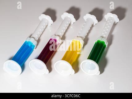 Ein Set mehrfarbiger Spritzen mit verschiedenen Düften auf der Toilettenschüssel in der Toilette zur Reinigung und Desinfektion. Hygiene und antibakterielle Wirkung Stockfoto