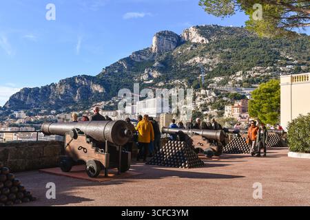 Touristen genießen die Aussicht von der Panoramaterrasse auf den Palastplatz mit Batterien alter Kanonen und dem Tête de Chien-Vorgebirge in Monaco Stockfoto