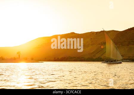 Felukenboot segelt bei Sonnenuntergang auf dem Nil Stockfoto