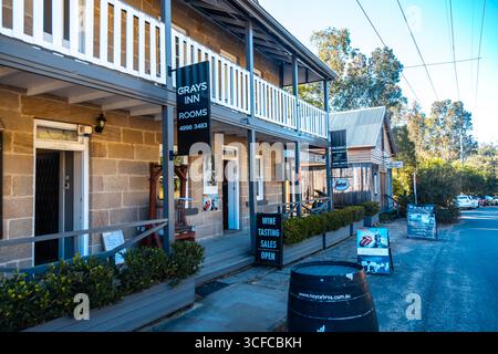 Wollombi, Hunter Region, NSW, Australien. Juli 2020. Wollombi ist ein historisches australisches Dorf im Hunter Valley, das für seinen historischen Charme und seine Kolonialarchitektur bekannt ist. Äußere der Unterkunft in Gray's Inn, ein wunderschönes altes, historisches Sandsteingebäude. Einige der Gebäude werden genutzt, um Musikfotografie und Rock'n'Roll-Abzüge auszustellen Stockfoto