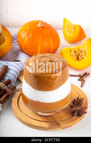 Kürbis-Gewürz-Dalgona-Kaffee-Cocktail, süßer, leckerer Herbstlatte mit Pumokinpüree, Schlagsahne und Schlagsahne-Instant-Dalgona-Kaffeeschaum Stockfoto