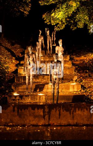 Beeindruckender nächtlicher Blick auf das Denkmal für die Opfer des Kommunismus Skulpturen auf dem Hügel Petřín in Prag, beleuchtet von warmen Lichtern Stockfoto