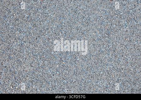 Detail der kompakten Gummifliese aus kleinen Stücken zur Dämpfung in Kinderspielbereichen im Freien. Draufsicht. Stockfoto