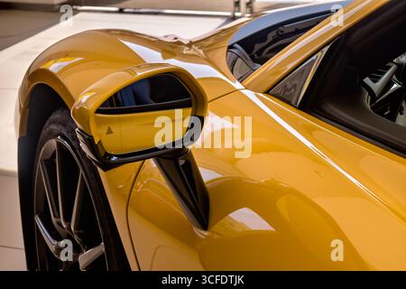 Nahaufnahme des Seitenspiegels eines gelben Autos. Stockfoto