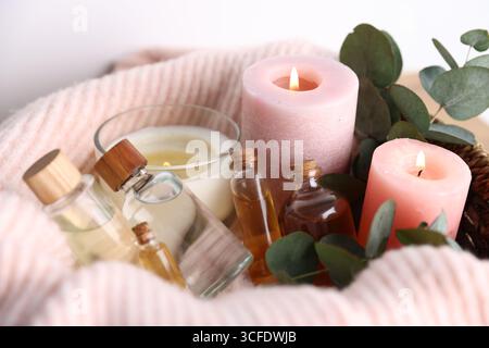 Spa-Zusammensetzung. Brennende Kerzen, Kosmetika und Eukalyptuszweige auf dem Tisch, Nahaufnahme Stockfoto