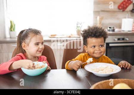 Geschwister mit unterschiedlichem Hintergrund genießen das Frühstück zu Hause Stockfoto