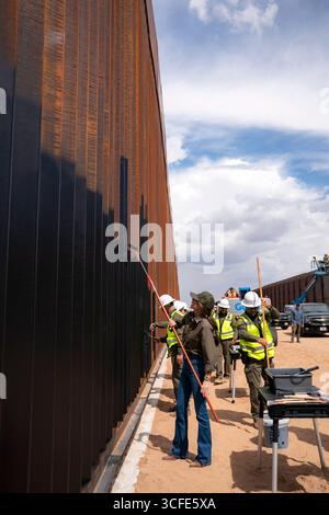 Santa Teresa, Usa. August 2025. Heimatschutzministerin Kristi Noem, links, verwendet eine Malerwalze, um schwarze Farbe auf die US-mexikanische Grenzmauer aufzutragen, auf Befehl von Präsident Donald Trump, 19. August 2025 in Santa Teresa, New Mexico. Quelle: TIA Dufour/CBP Photo/Alamy Live News Stockfoto