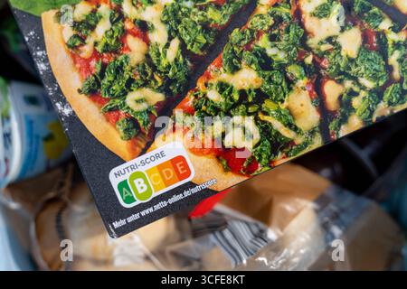 Bayern, Deutschland - 22. August 2025: Nutri-Score-Kennzeichnung auf einer Packung gefrorener Pizza. Die farbige Lebensmittelampel informiert Verbraucher über Nährwerte und hilft ihnen, gesunde oder ungesunde Lebensmittel zu wählen *** Nutri-Score-Kennzeichnung auf einer Packung Tiefkühlpizza. Die farbige Lebensmittelampel informiert Verbraucher über Nährwerte und hilft bei gesunder oder ungesunder Ernährungswahl Stockfoto