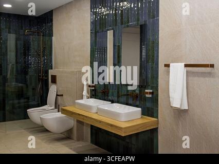 Modernes Badezimmer mit Keramikfliesen und Spiegeln an der Wand Stockfoto