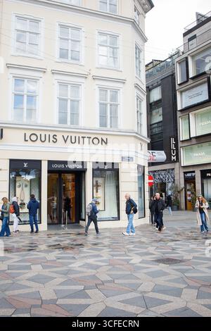 Louis Vuitton Luxusbekleidungsgeschäft im Stadtzentrum von Kopenhagen, Dänemark. Eingang, Schaufenster, Logo-Schild und Personen in der Nähe des Stores. Stockfoto