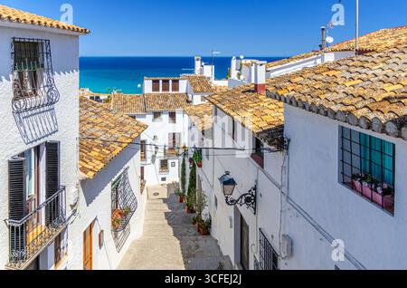 Altea Altstadt enge Straße mit typischen weißen Häusern traditionelle Gebäude, Altea Bucht Mittelmeer azurblaues Wasser an sonnigen Sommertagen, Altea Stadt Stockfoto