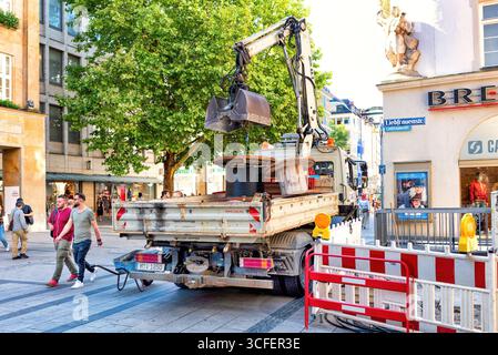 MÜNCHEN, DEUTSCHLAND - 12. SEPTEMBER 2018: Arbeiter, die Glasfaserkabel für Internet und Telefon installieren, Stromleitungen auf der Straße installieren. Stockfoto