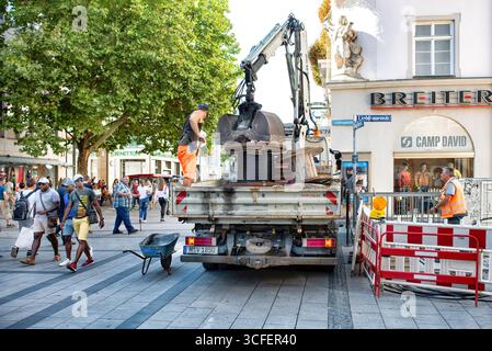 MÜNCHEN, DEUTSCHLAND - 12. SEPTEMBER 2018: Arbeiter, die Glasfaserkabel für Internet und Telefon installieren, Stromleitungen auf der Straße installieren. Stockfoto