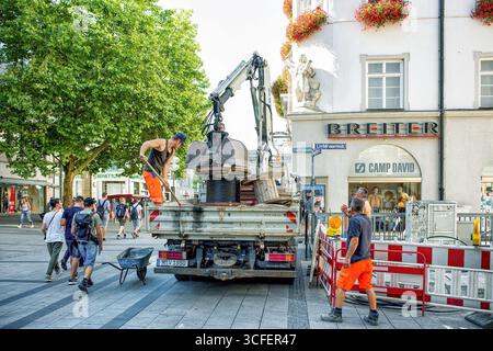 MÜNCHEN, DEUTSCHLAND - 12. SEPTEMBER 2018: Arbeiter, die Glasfaserkabel für Internet und Telefon installieren, Stromleitungen auf der Straße installieren. Stockfoto