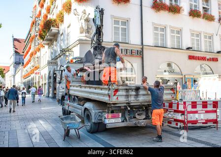 MÜNCHEN, DEUTSCHLAND - 12. SEPTEMBER 2018: Arbeiter, die Glasfaserkabel für Internet und Telefon installieren, Stromleitungen auf der Straße installieren. Stockfoto