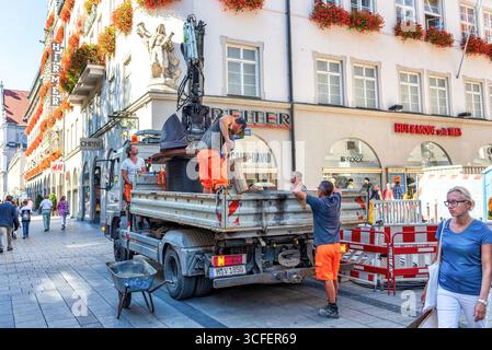 MÜNCHEN, DEUTSCHLAND - 12. SEPTEMBER 2018: Arbeiter, die Glasfaserkabel für Internet und Telefon installieren, Stromleitungen auf der Straße installieren. Stockfoto