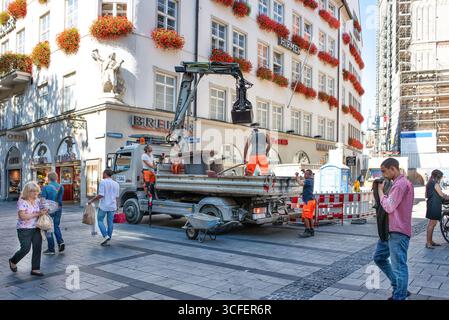 MÜNCHEN, DEUTSCHLAND - 12. SEPTEMBER 2018: Arbeiter, die Glasfaserkabel für Internet und Telefon installieren, Stromleitungen auf der Straße installieren. Stockfoto