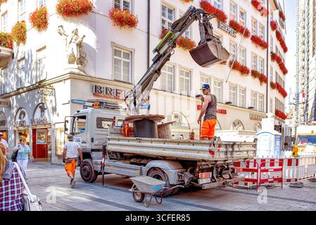 MÜNCHEN, DEUTSCHLAND - 12. SEPTEMBER 2018: Arbeiter, die Glasfaserkabel für Internet und Telefon installieren, Stromleitungen auf der Straße installieren. Stockfoto