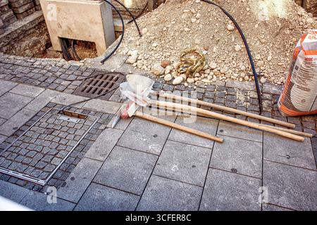 MÜNCHEN, DEUTSCHLAND - 12. SEPTEMBER 2018: Installation von Glasfaserkabeln für Internet und Telefon, Installation von Stromleitungen auf der Straße. Stockfoto