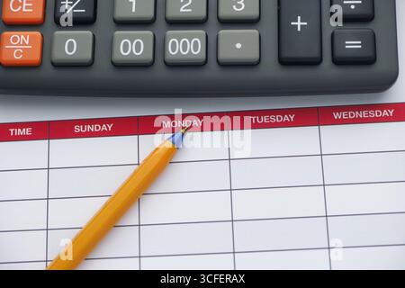 Ein Wochenplan mit einem Kugelschreiber und einem Taschenrechner darauf. Nahaufnahme. Stockfoto