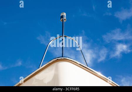 Der Bug der Yacht mit einer Signallampe vor dem Hintergrund eines blauen Himmels mit Wolken, Ansicht von unten. Stockfoto