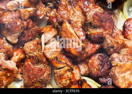 Schaschlieren Sie Kebab-Stücke mit Zwiebeln. Frittierte Schweinefleischstücke. Stockfoto