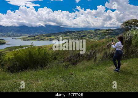 Weibliche Touristen, die Fotos am größten künstlichen See Kolumbiens machen, Calima Lake, der sich in den Bergen von Darien in der Region Valle befindet Stockfoto
