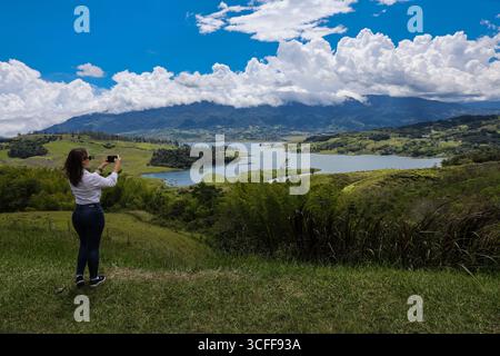 Weibliche Touristen, die Fotos am größten künstlichen See Kolumbiens machen, Calima Lake, der sich in den Bergen von Darien in der Region Valle befindet Stockfoto