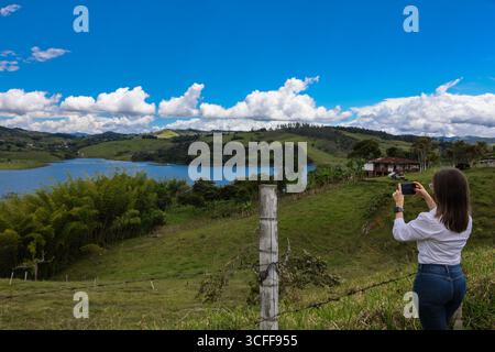 Weibliche Touristen, die Fotos am größten künstlichen See Kolumbiens machen, Calima Lake, der sich in den Bergen von Darien in der Region Valle befindet Stockfoto