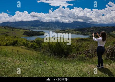 Weibliche Touristen, die Fotos am größten künstlichen See Kolumbiens machen, Calima Lake, der sich in den Bergen von Darien in der Region Valle befindet Stockfoto