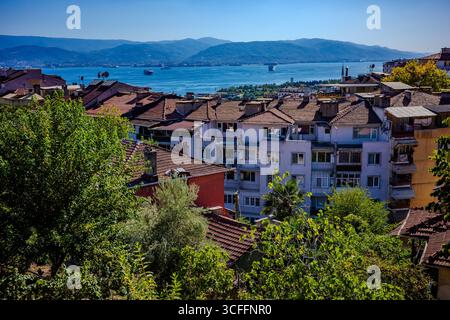 Malerische Aussicht auf Izmit mit farbenfrohen Dächern, üppigem Grün und die Bucht, die sich zu Bergen unter einem klaren Sommerhimmel erstreckt. Stockfoto