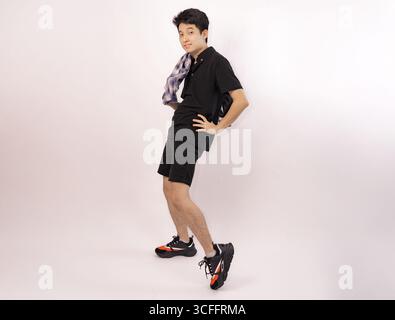 Junger Mann posiert spielerisch in kariertem Hemd mit lässigem Outfit Stockfoto