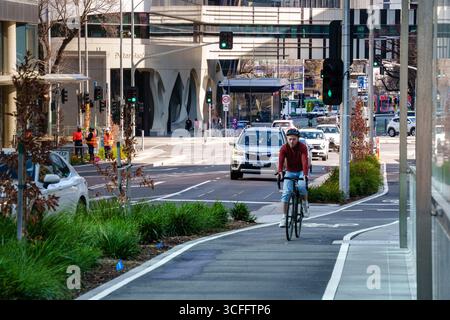 Ein Mann fährt mit dem Fahrrad auf dem geschützten Radweg Grattan Street in Melbourne Stockfoto